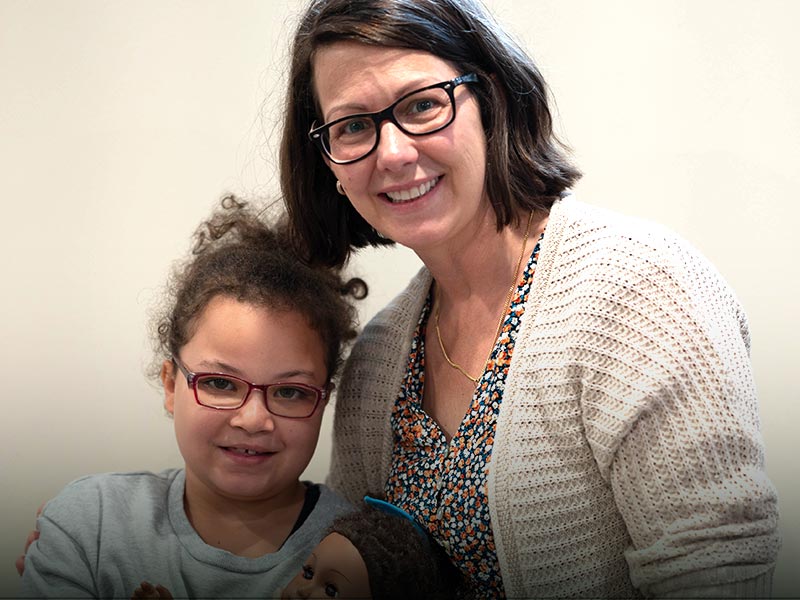 One of our children leaders smiling next to a child